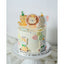 A decorated butter cream cake with animal-themed toppers, presented on a white cake stand.